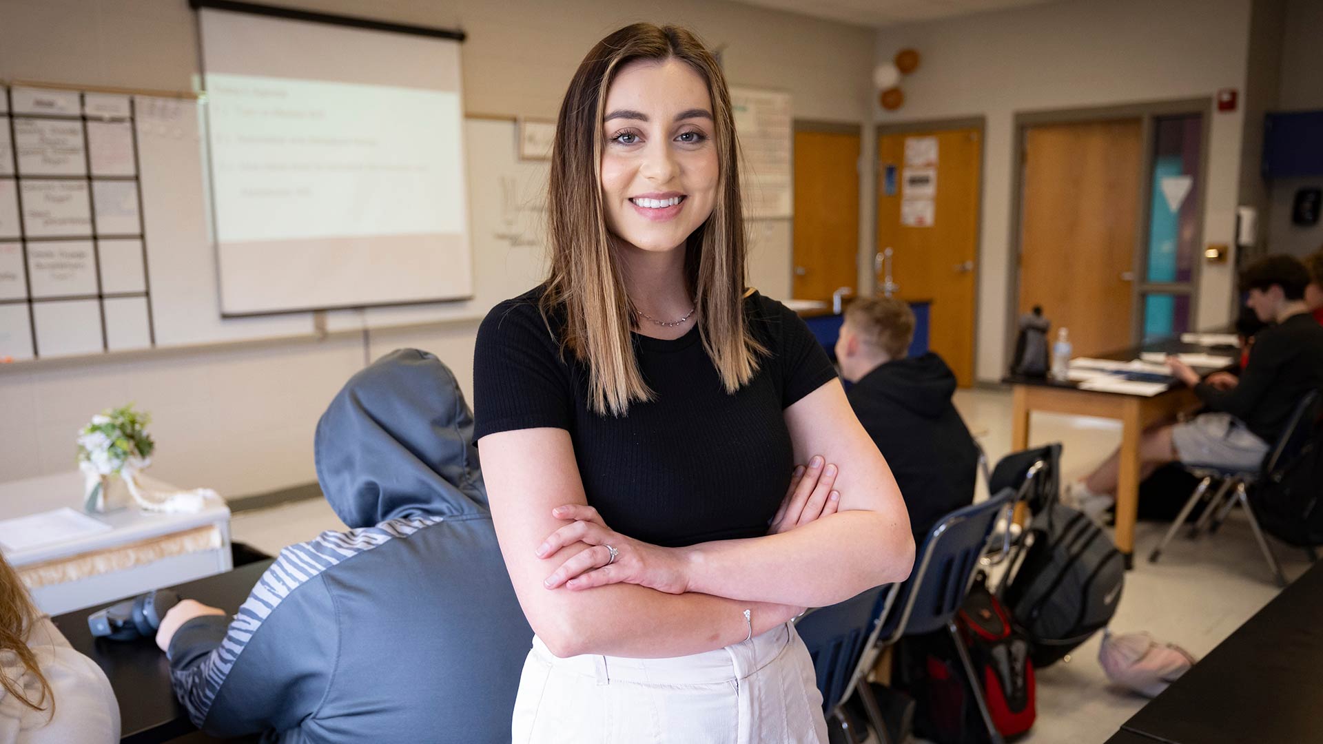 A high school science teacher poses for a photo in her classroom.