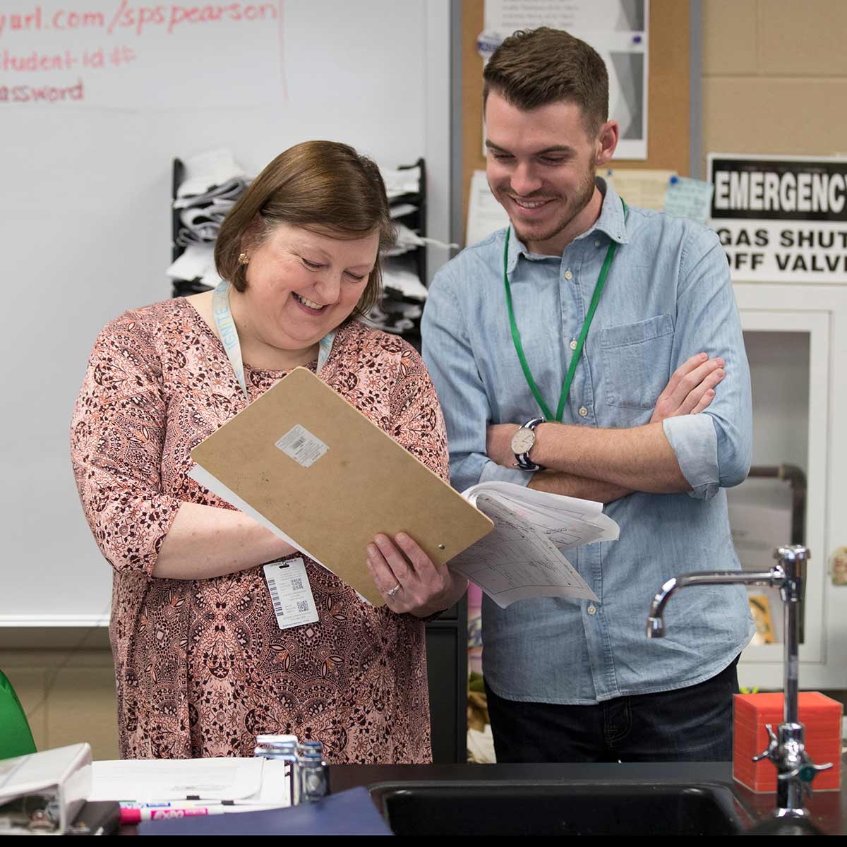 A student teacher shares a laugh with a high school teacher during a science class.