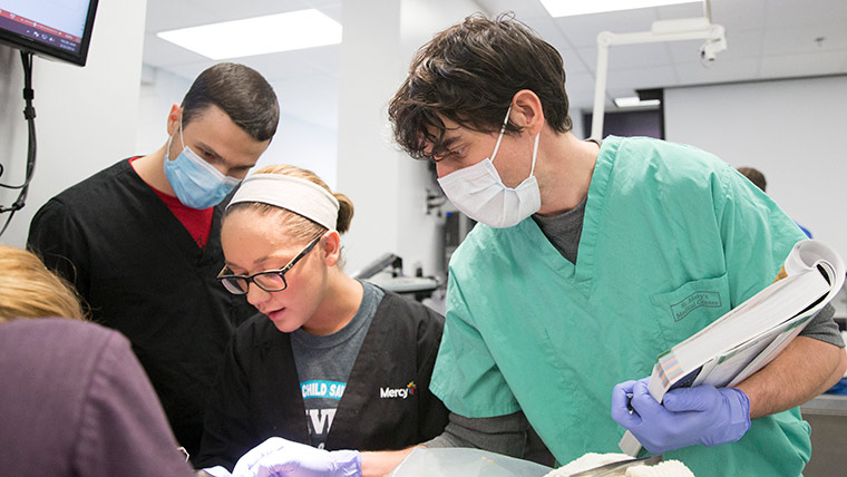 Medical students in a graduate-level class conduct practice medical check-ups.